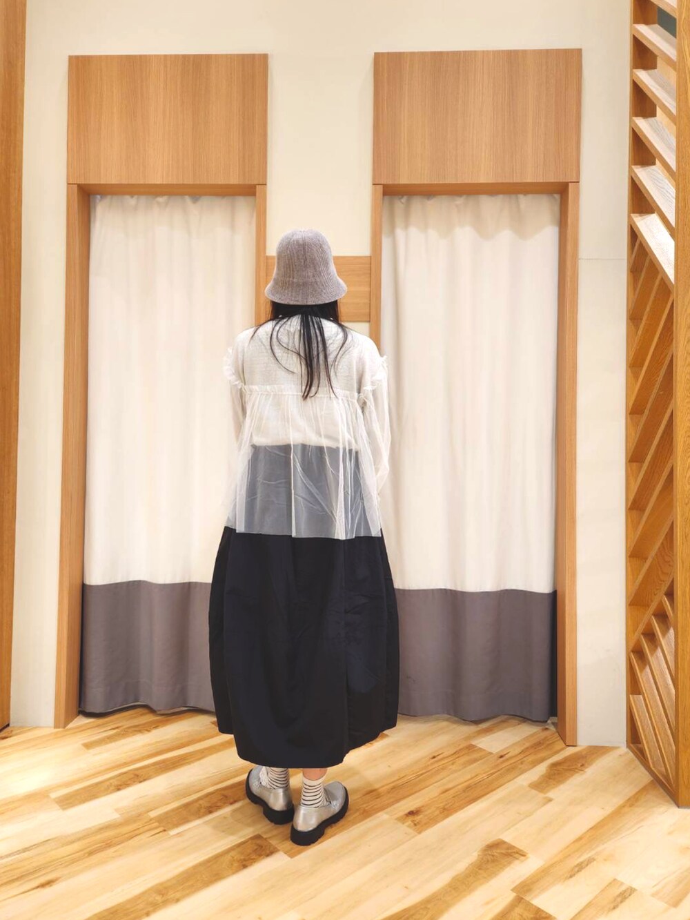 シルバー系のドレスシューズ、ブラック系のハンドバッグ、ホワイト系のニット/セーターを着用したレディースの秋コーディネートの2枚目の写真