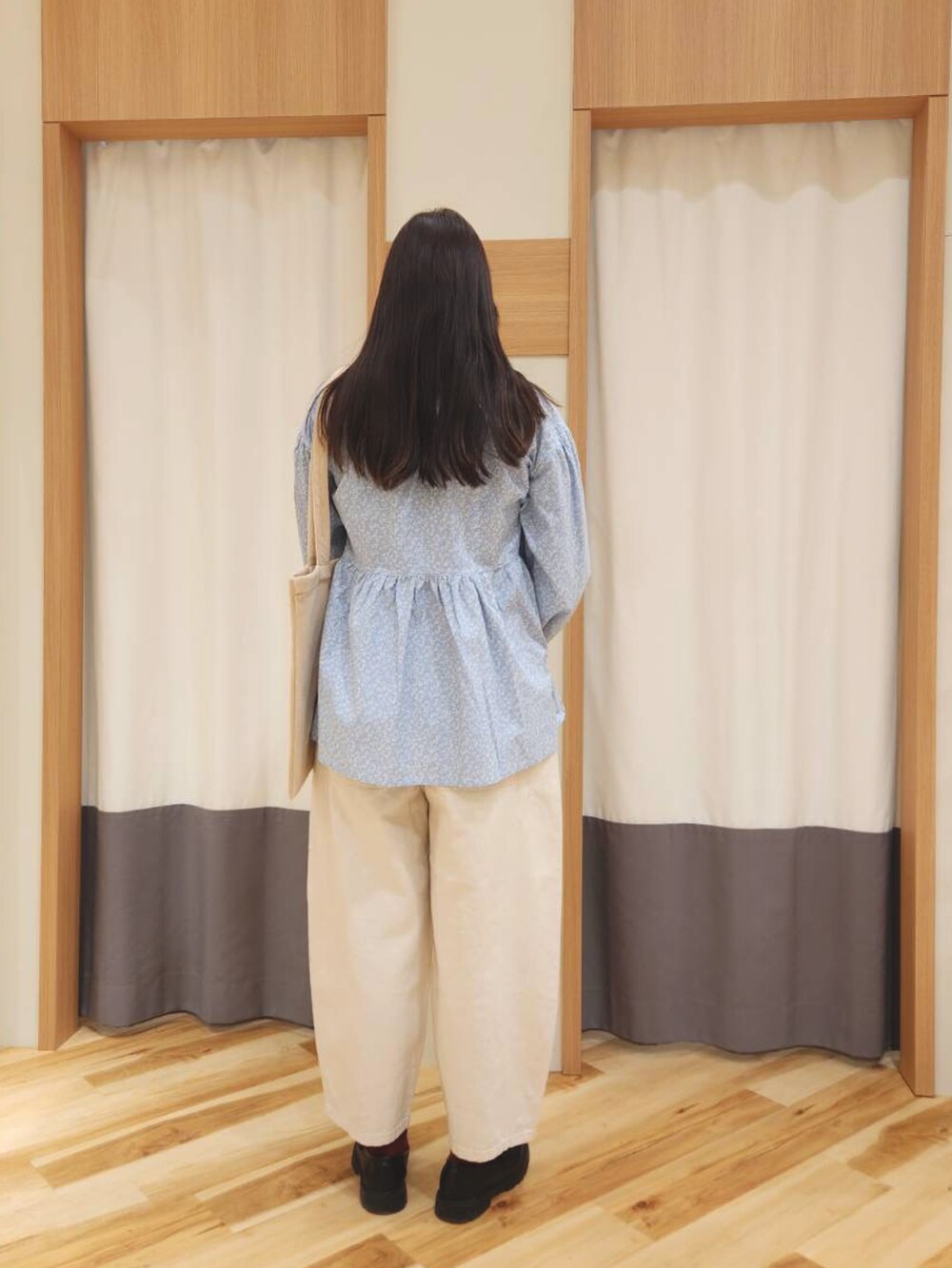 ブルー系のシャツ/ブラウス、ベージュ系のハンドバッグ、ホワイト系のその他パンツを着用したレディースの冬コーディネートの2枚目の写真