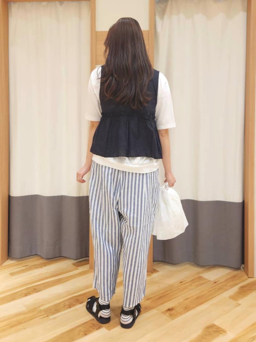 ブラック系のサンダル、ブルー系のその他パンツ、ホワイト系のTシャツ/カットソーを着用したレディースの春コーディネートの2枚目の写真