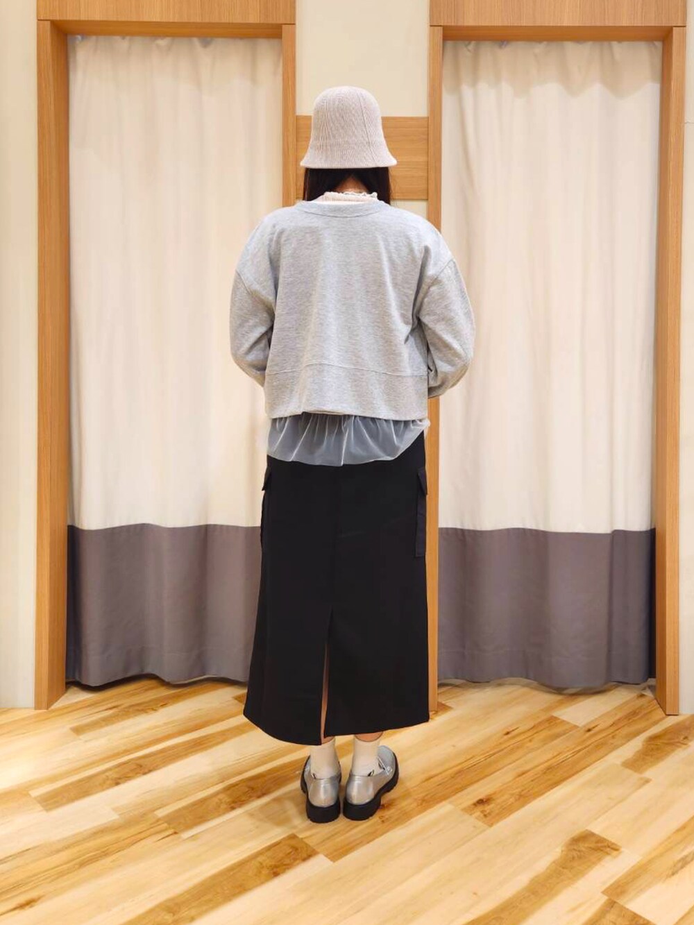 ブラック系のニット/セーター、グレー系のTシャツ/カットソー、ホワイト系のTシャツ/カットソーを着用したレディースの秋コーディネートの2枚目の写真