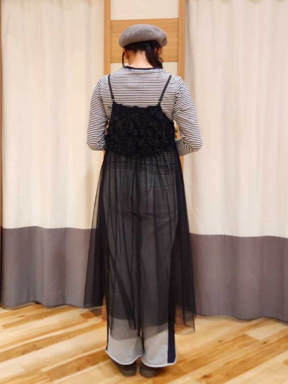 グレー系のTシャツ/カットソー、グレー系のその他パンツ、ブラック系のワンピースを着用したレディースの冬コーディネートの2枚目の写真