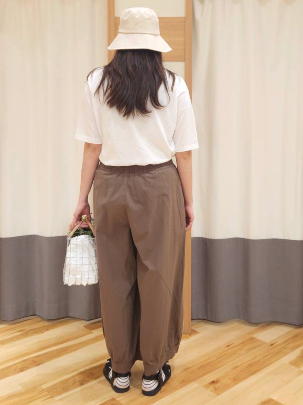 ブラック系のサンダル、ブラウン系のその他パンツ、ホワイト系のハンドバッグを着用したレディースの春コーディネートの2枚目の写真