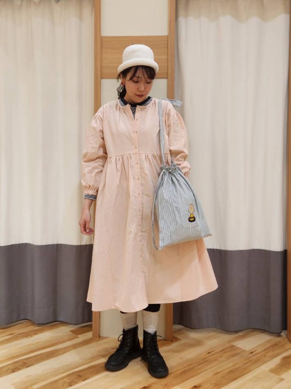 ピンク系のワンピース、グレー系のTシャツ/カットソー、グリーン系のハンドバッグを着用したレディースの冬コーディネートの2枚目の写真