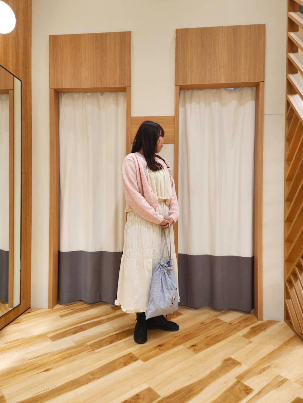 グレー系のTシャツ/カットソー、ピンク系のカーディガン/ボレロ、グリーン系のハンドバッグを着用したレディースの冬コーディネートの2枚目の写真