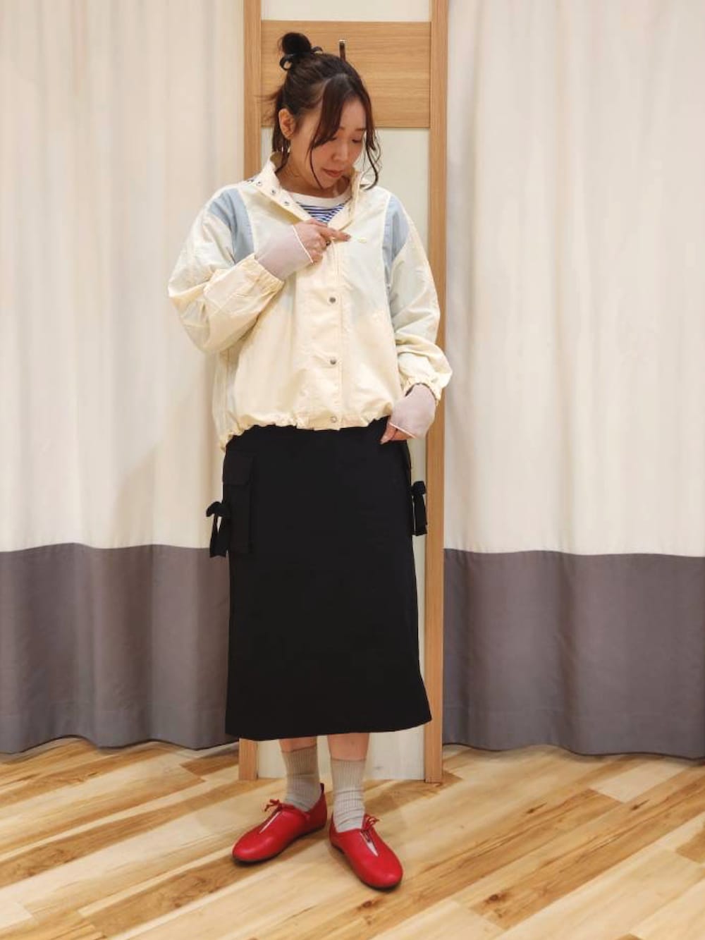 レッド系のドレスシューズ、ブラック系のスカート、ホワイト系のブルゾンを着用したレディースの春コーディネートの2枚目の写真