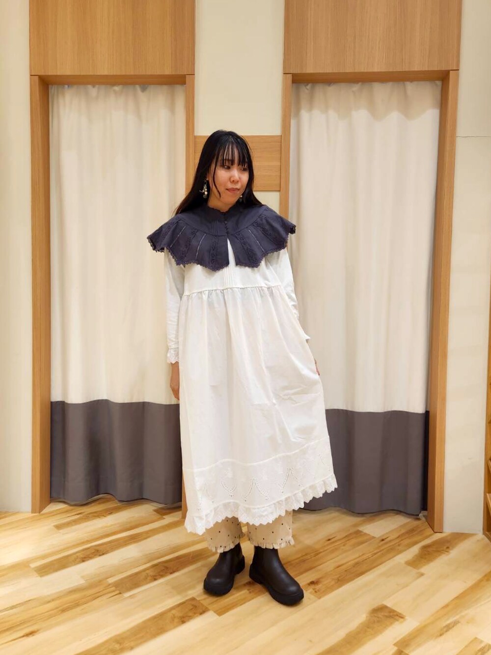 ホワイト系のワンピース、ホワイト系のその他パンツ、ブラック系のブーツを着用したレディースの秋コーディネートの2枚目の写真