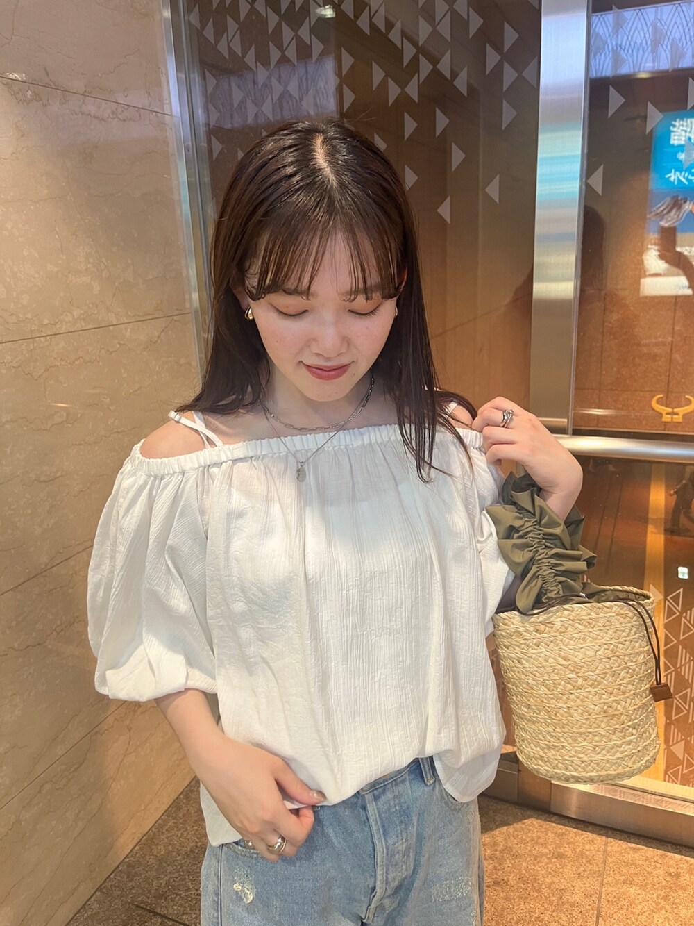 ホワイト系のシャツ/ブラウス、ブルー系のデニムパンツ、ベージュ系のショルダーバッグを着用したレディースの春コーディネートの3枚目の写真