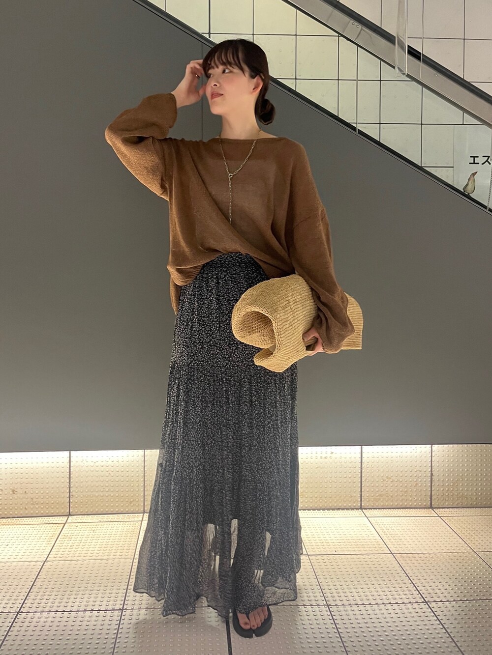 ブラウン系のニット/セーター、ピンク系のスカート、ベージュ系のかごバッグを着用したレディースの夏コーディネートの4枚目の写真