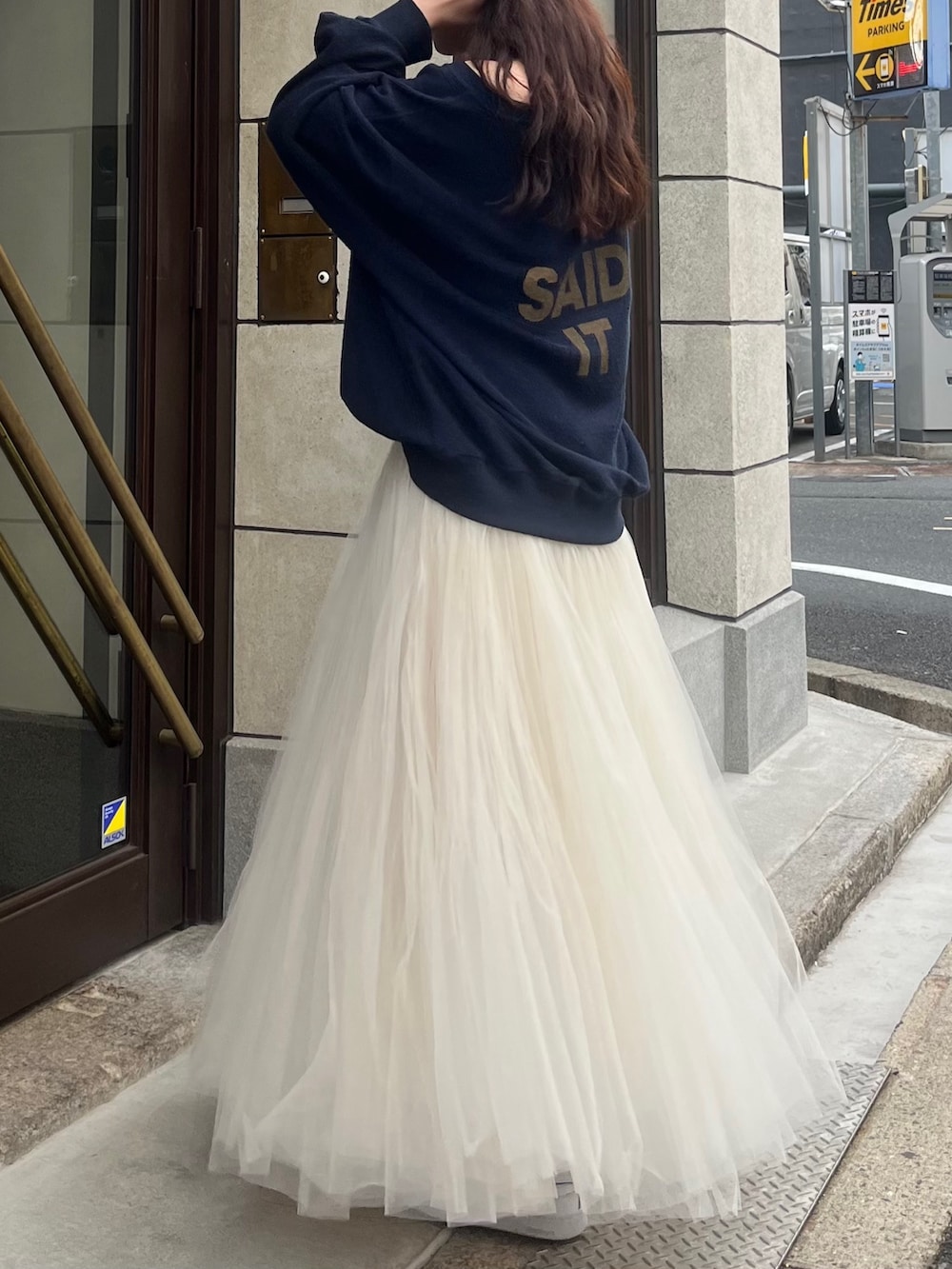 ホワイト系のスカート、ブルー系のTシャツ/カットソー、ブラック系のベルトを着用したレディースの冬コーディネートの2枚目の写真