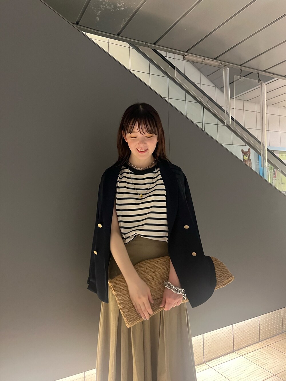 シルバー系のサンダル、ベージュ系のスカート、ブルー系のテーラードジャケットを着用したレディースの春コーディネートの5枚目の写真