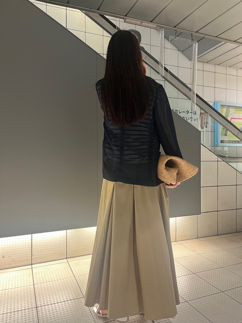 シルバー系のサンダル、ベージュ系のスカート、ブルー系のテーラードジャケットを着用したレディースの春コーディネートの2枚目の写真