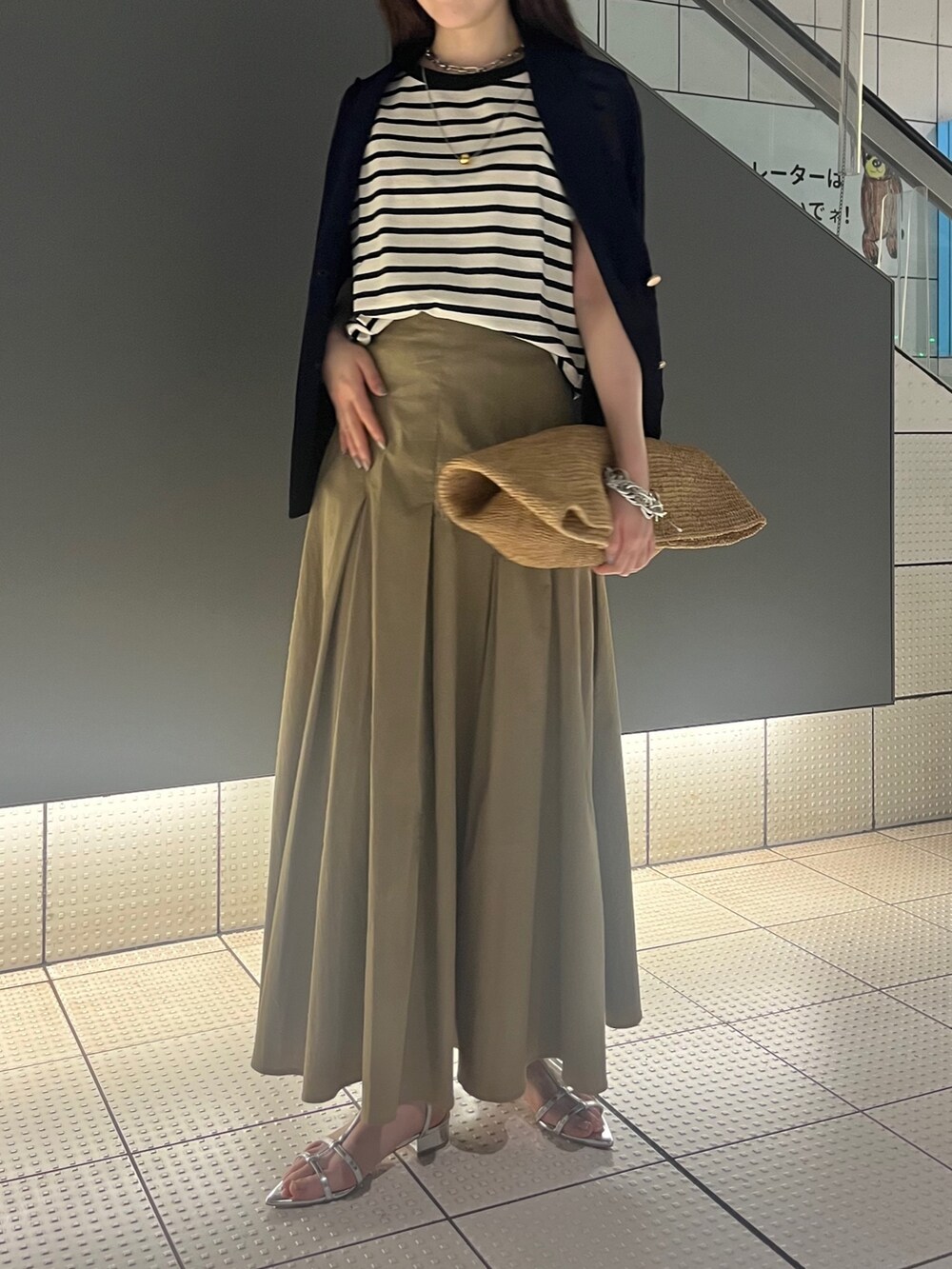 シルバー系のサンダル、ベージュ系のスカート、ブルー系のテーラードジャケットを着用したレディースの春コーディネートの4枚目の写真