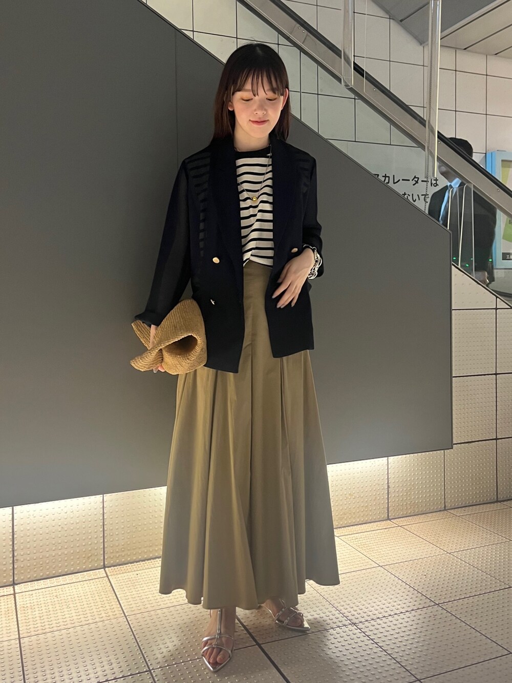 シルバー系のサンダル、ベージュ系のスカート、ブルー系のテーラードジャケットを着用したレディースの春コーディネートの3枚目の写真