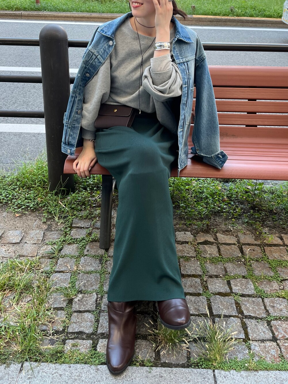ブルー系のその他アウター、ブラウン系のショルダーバッグ、グリーン系のスカートを着用したレディースの秋コーディネートの8枚目の写真