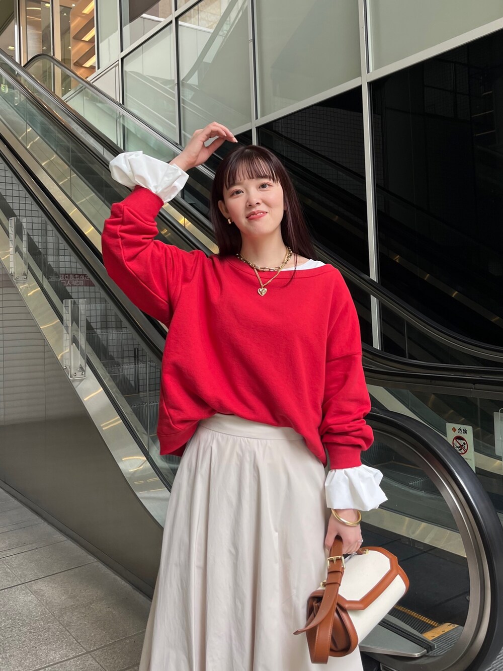 レッド系のスウェット、ホワイト系のTシャツ/カットソー、ホワイト系のスニーカーを着用したレディースの春コーディネートの3枚目の写真