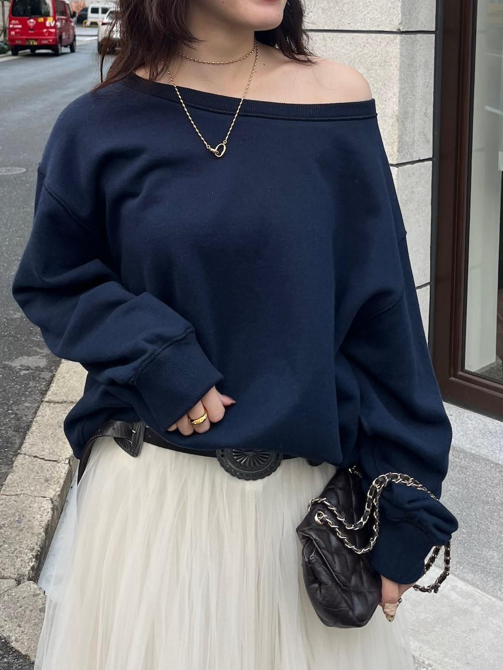 ホワイト系のスカート、ブルー系のTシャツ/カットソー、ブラック系のベルトを着用したレディースの冬コーディネートの3枚目の写真