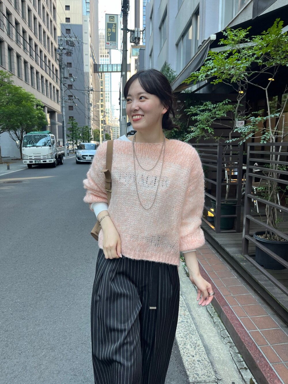 ピンク系のニット/セーター、ベージュ系のショルダーバッグ、ブルー系のその他パンツを着用したレディースの秋コーディネートの5枚目の写真