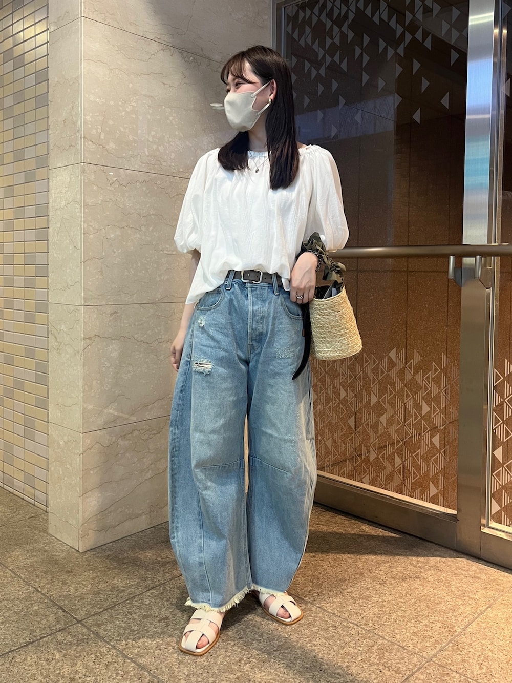 ホワイト系のシャツ/ブラウス、ブルー系のデニムパンツ、ベージュ系のショルダーバッグを着用したレディースの春コーディネートの2枚目の写真