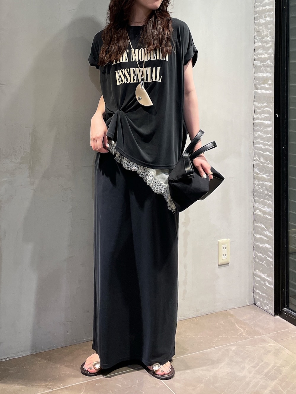 ブラック系のスカート、ホワイト系のシャツ/ブラウス、ブラック系のTシャツ/カットソーを着用したレディースの夏コーディネートの3枚目の写真