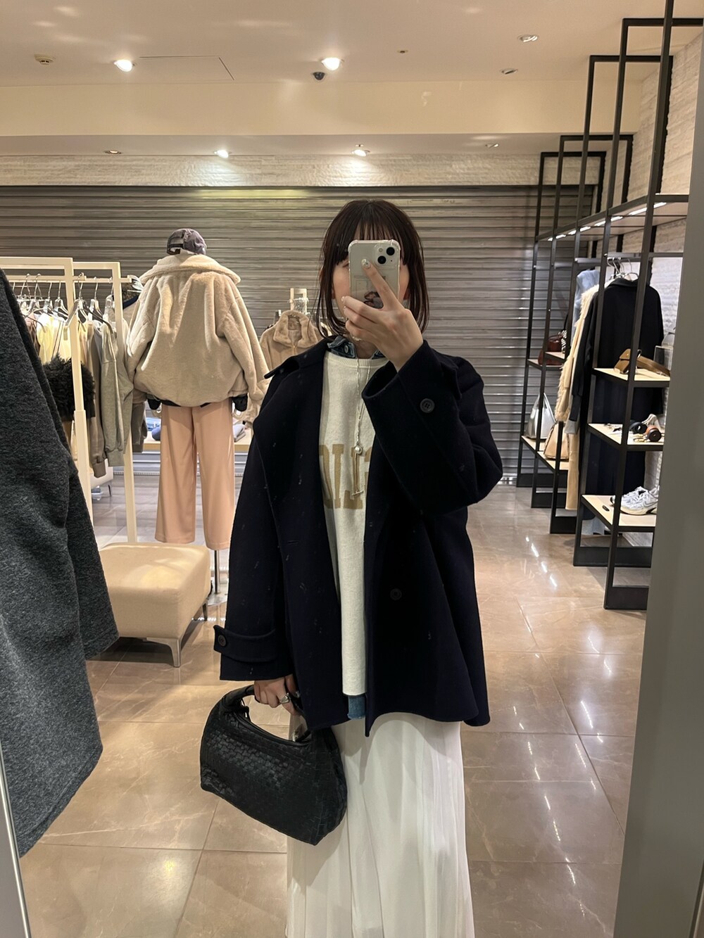 ホワイト系のスカート、ブルー系のシャツ/ブラウス、ホワイト系のニット/セーターを着用したレディースの冬コーディネートの3枚目の写真