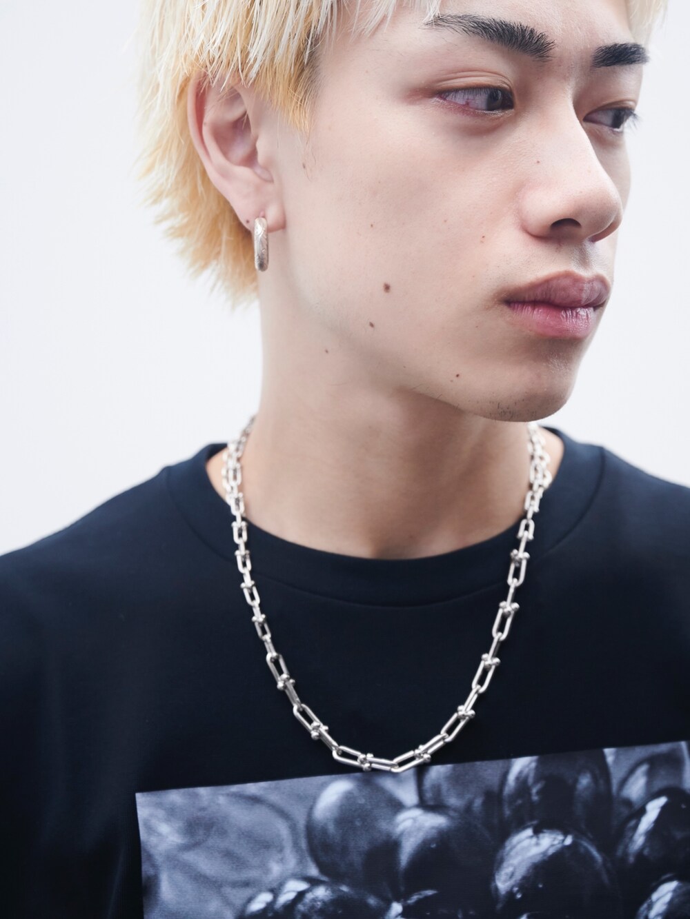 ホワイト系のTシャツ/カットソー、ブラック系のスラックス、ブラック系のサンダルを着用したメンズの夏コーディネートの5枚目の写真