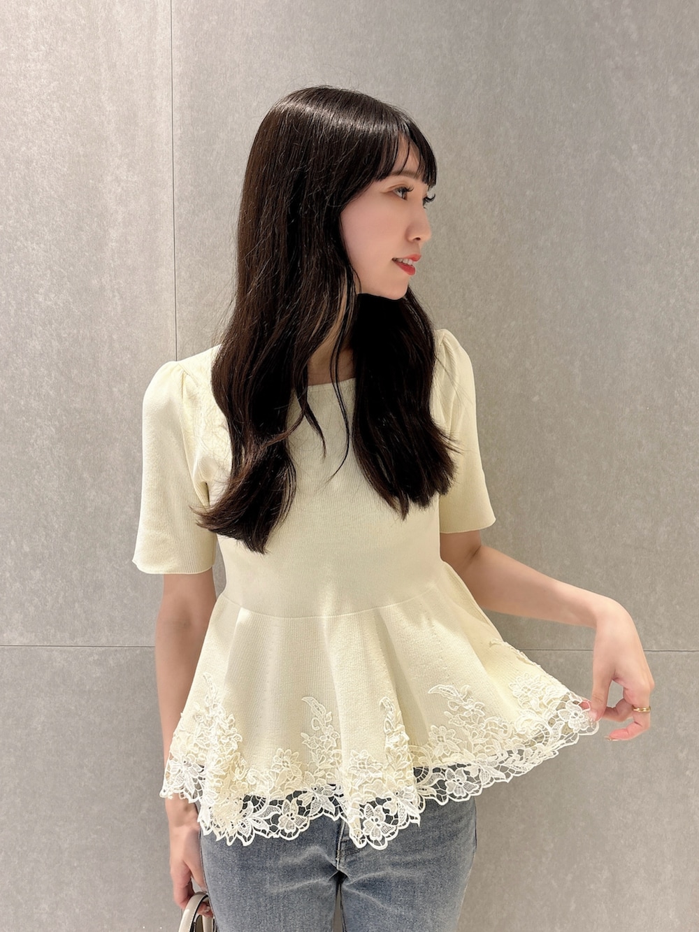 ホワイト系のニット/セーター、ブルー系のデニムパンツ、ホワイト系のショルダーバッグを着用したレディースの夏コーディネートの7枚目の写真