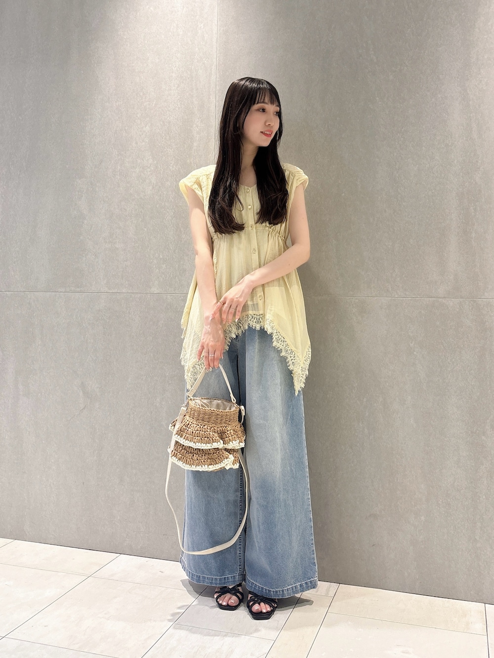 イエロー系のシャツ/ブラウス、ブルー系のその他パンツ、ベージュ系のショルダーバッグを着用したレディースの春コーディネートの3枚目の写真