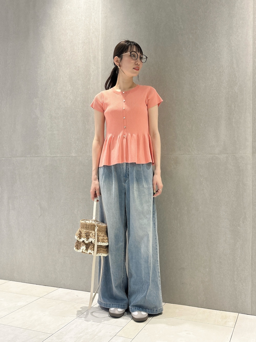 ピンク系のニット/セーター、ブルー系のその他パンツ、ベージュ系のショルダーバッグを着用したレディースの春コーディネートの4枚目の写真