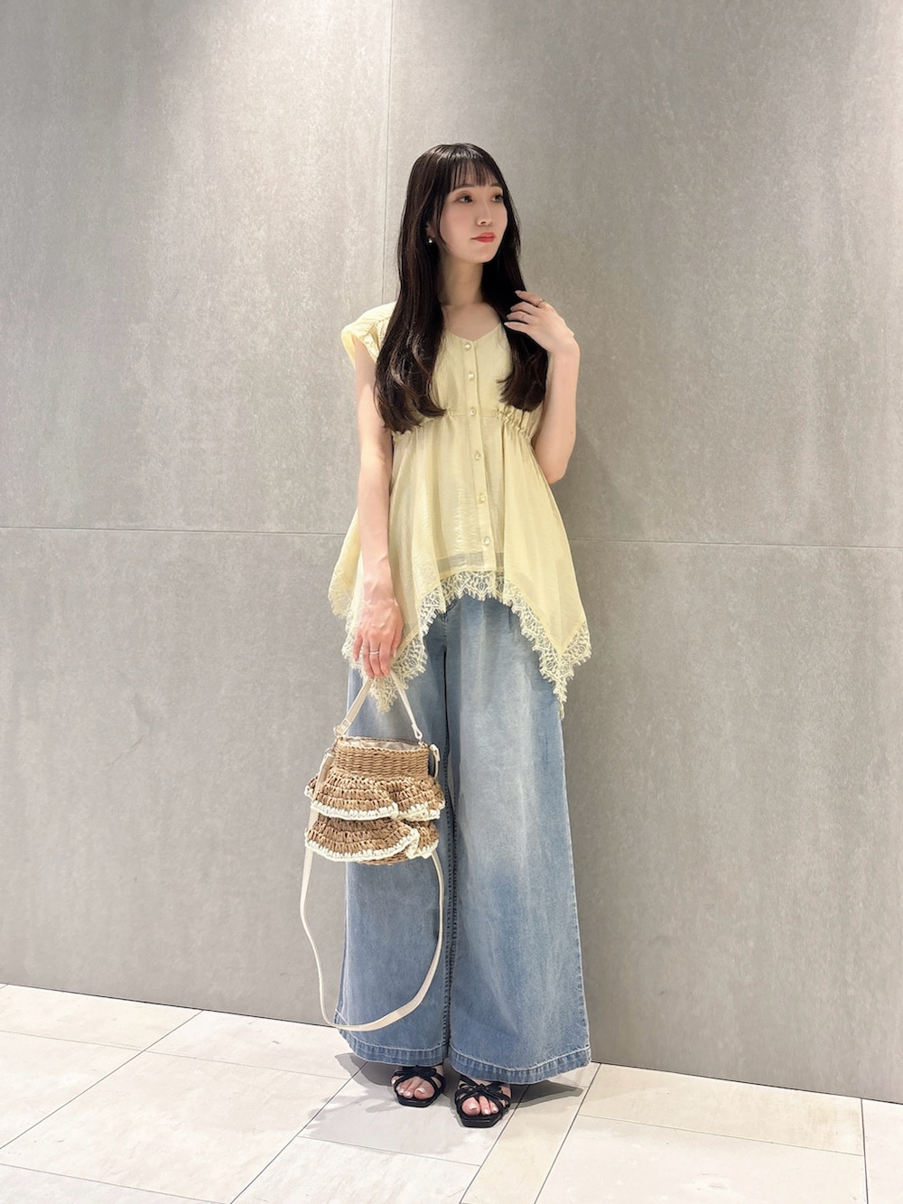 イエロー系のシャツ/ブラウス、ブルー系のその他パンツ、ベージュ系のショルダーバッグを着用したレディースの春コーディネートの2枚目の写真