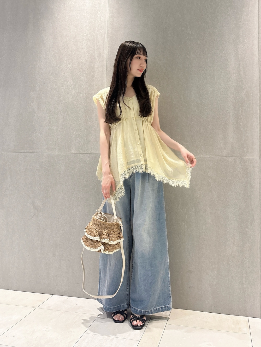 イエロー系のシャツ/ブラウス、ブルー系のその他パンツ、ベージュ系のショルダーバッグを着用したレディースの春コーディネートの4枚目の写真