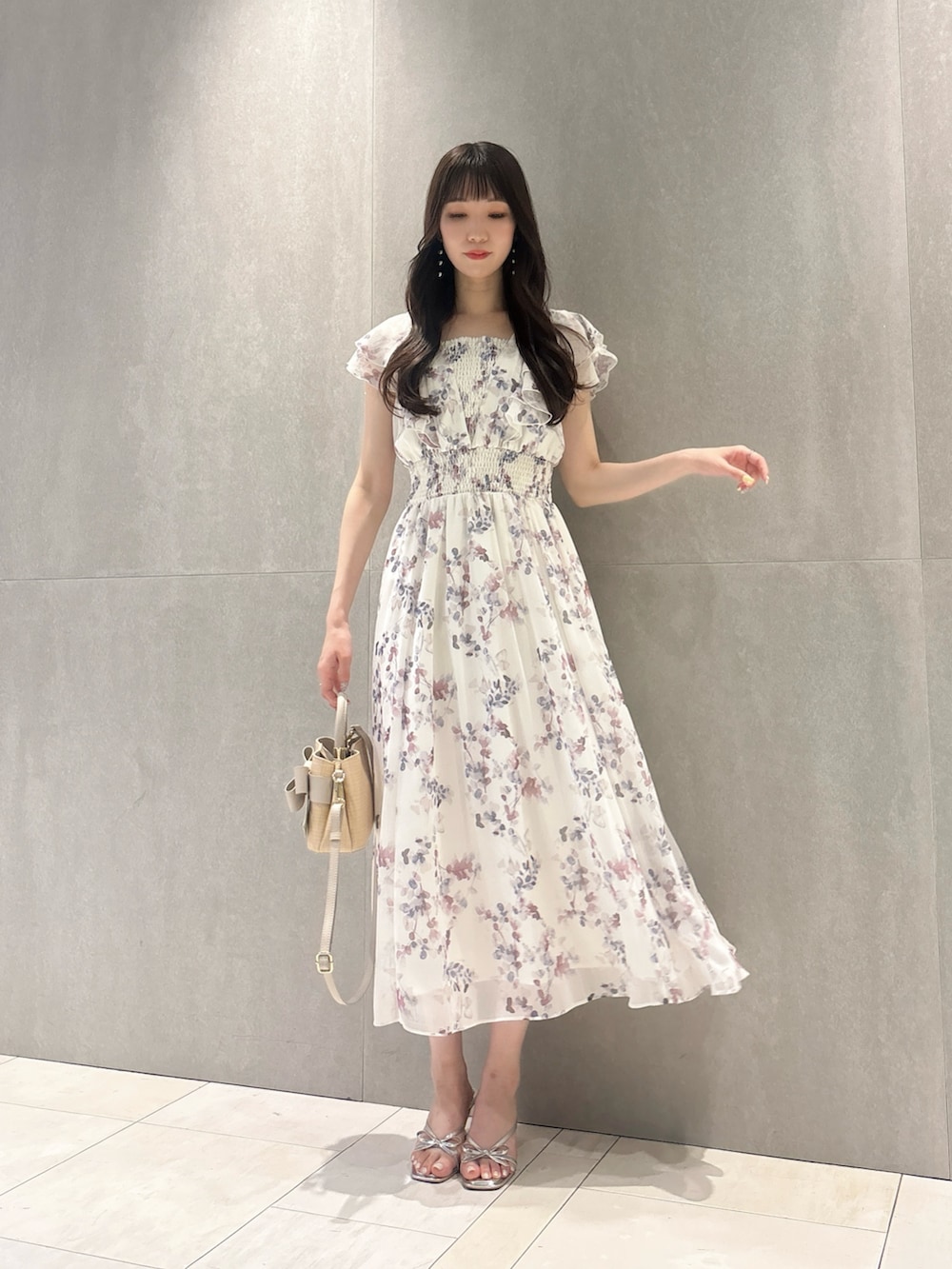 パープル系のワンピース、ホワイト系のショルダーバッグ、シルバー系のパンプスを着用したレディースの春コーディネートの4枚目の写真