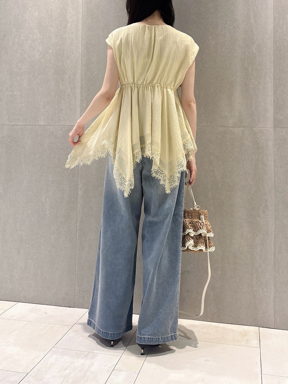 イエロー系のシャツ/ブラウス、ブルー系のその他パンツ、ベージュ系のショルダーバッグを着用したレディースの春コーディネートの7枚目の写真