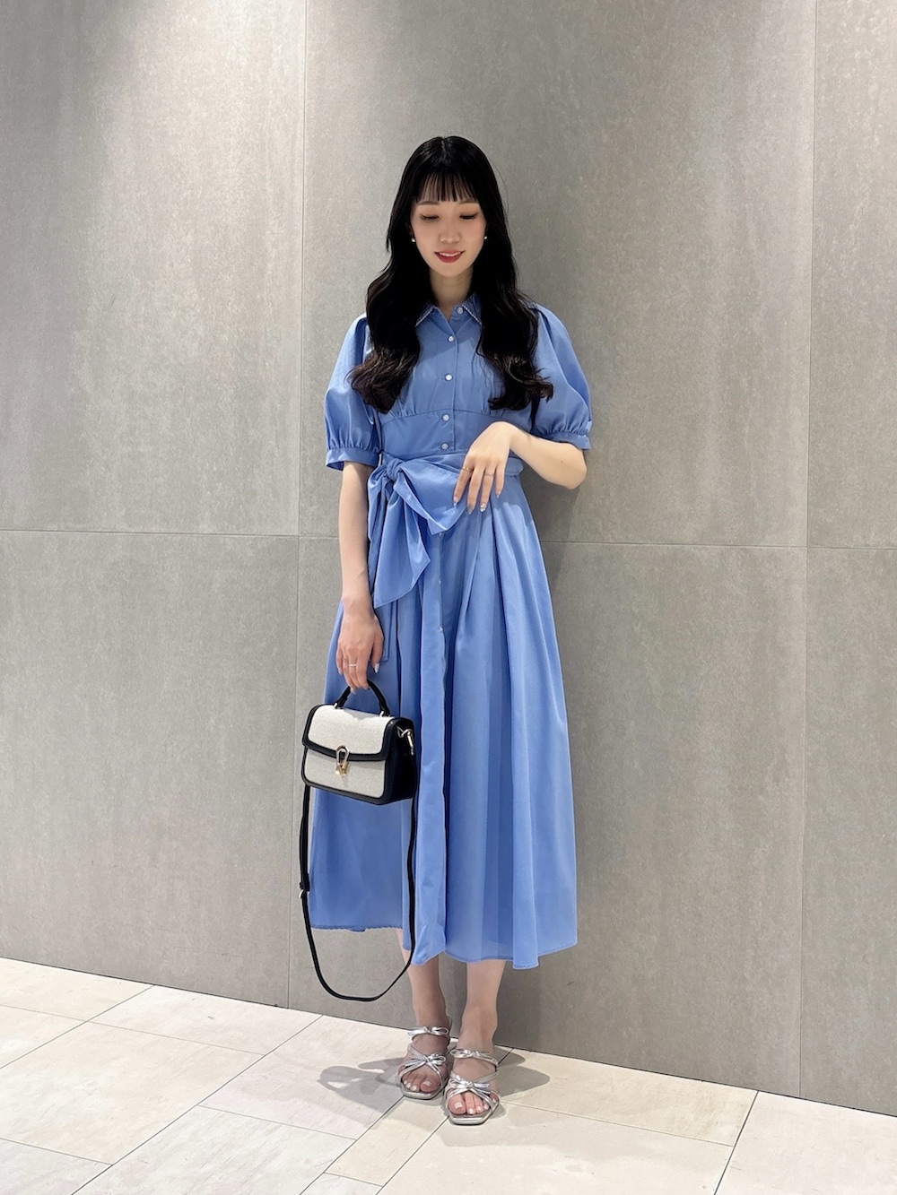 ブルー系のワンピース、ブラック系のショルダーバッグ、シルバー系のパンプスを着用したレディースの夏コーディネートの3枚目の写真