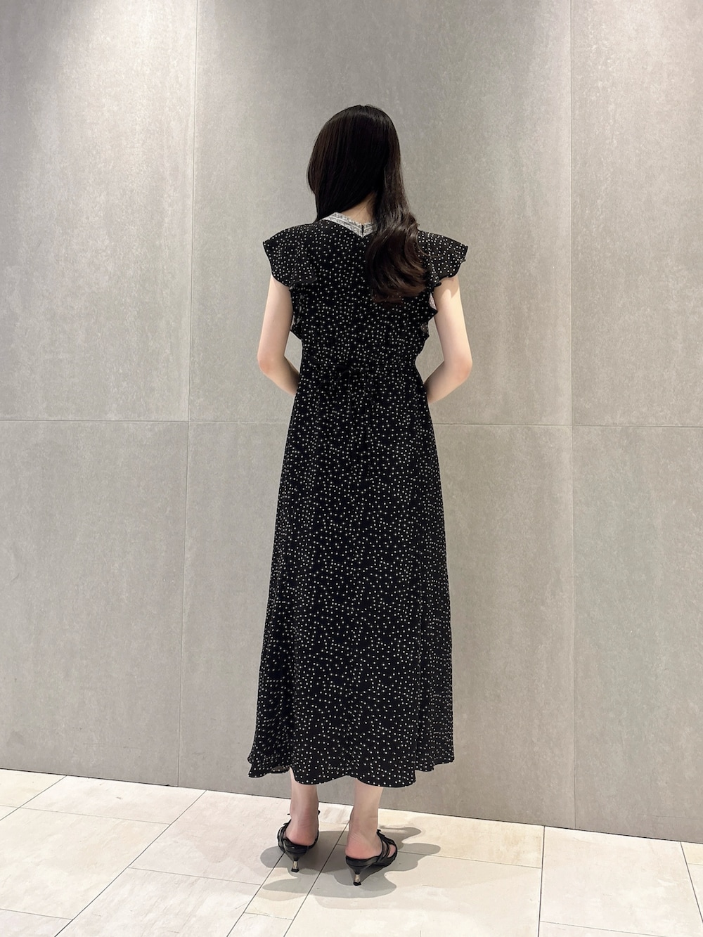 ブラック系のワンピース、ブラック系のパンプス、ホワイト系のショルダーバッグを着用したレディースの夏コーディネートの4枚目の写真