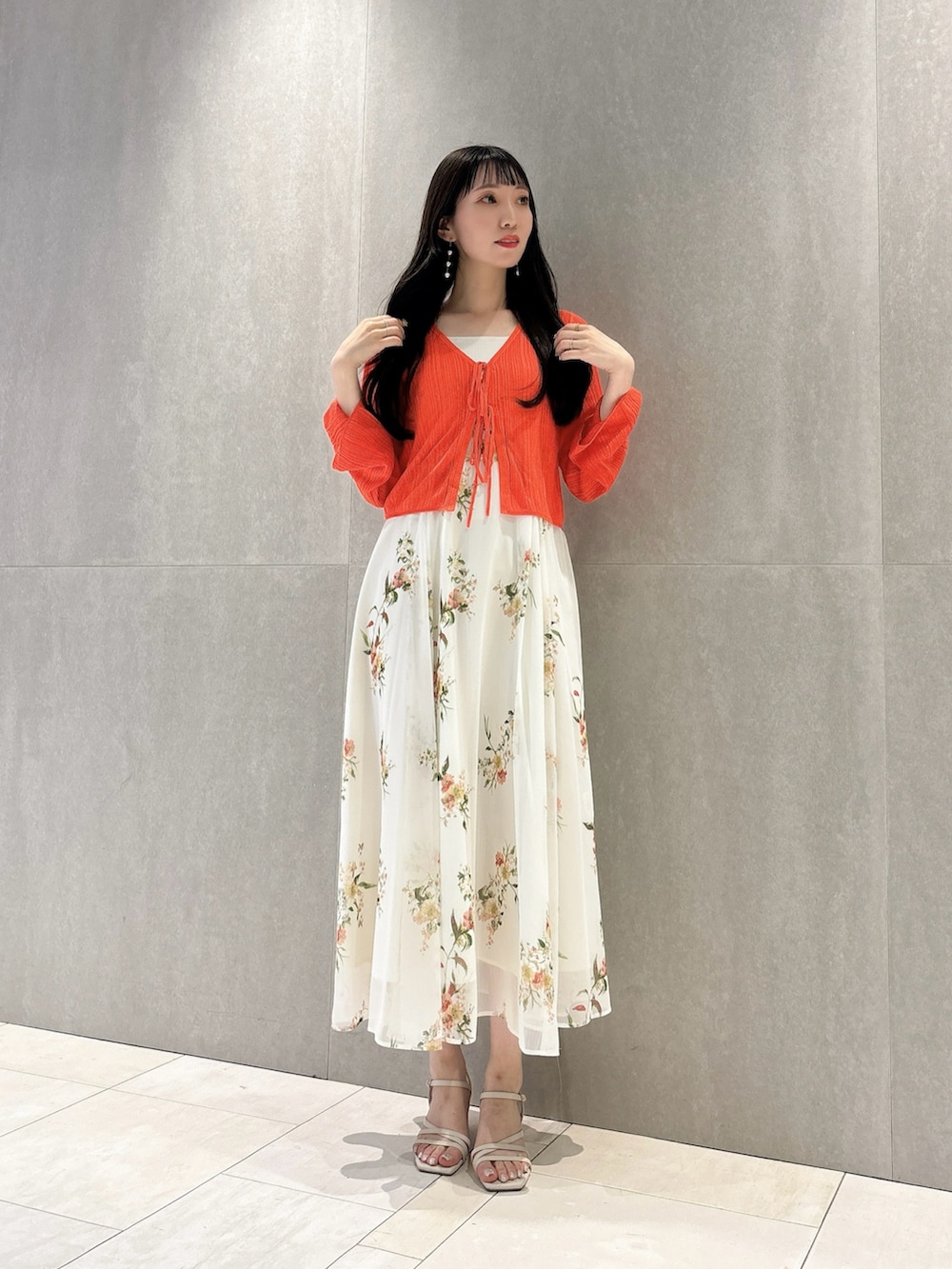 ピンク系のワンピース、オレンジ系のカーディガン/ボレロを着用したレディースの夏コーディネートの2枚目の写真