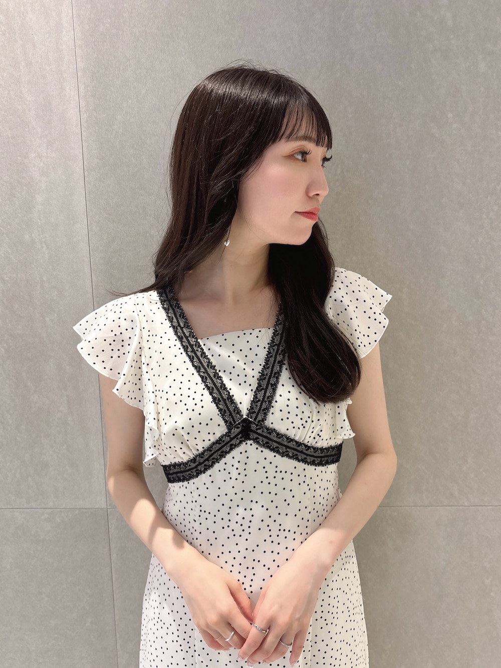ホワイト系のワンピース、ブラック系のパンプスを着用したレディースの夏コーディネートの8枚目の写真