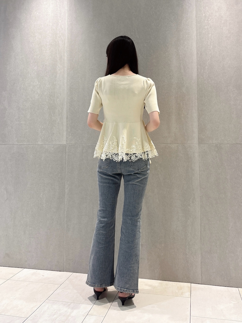 ホワイト系のニット/セーター、ブルー系のデニムパンツ、ホワイト系のショルダーバッグを着用したレディースの夏コーディネートの5枚目の写真