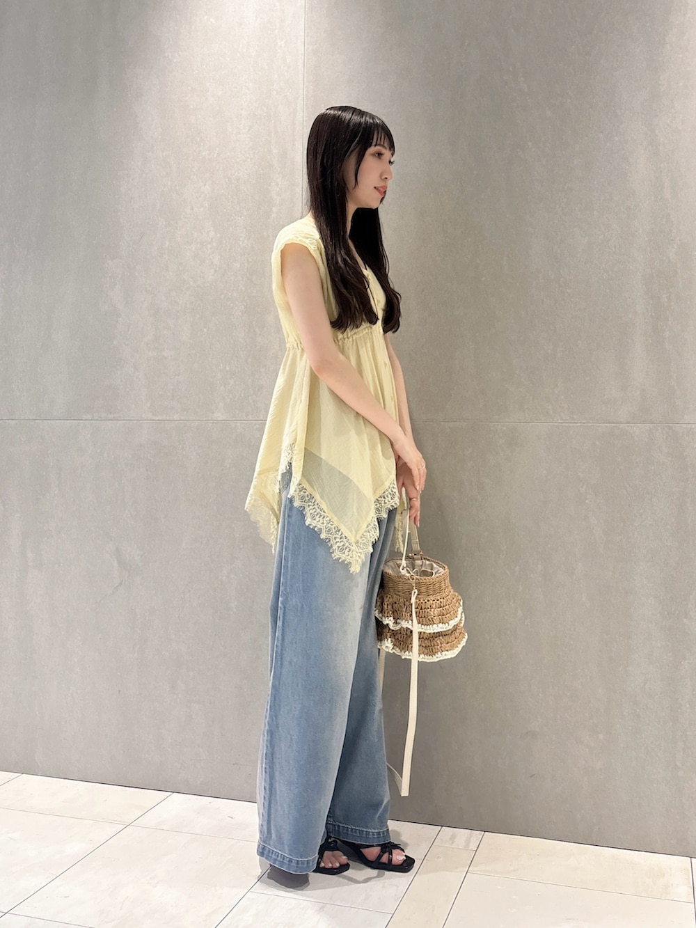 イエロー系のシャツ/ブラウス、ブルー系のその他パンツ、ベージュ系のショルダーバッグを着用したレディースの春コーディネートの6枚目の写真