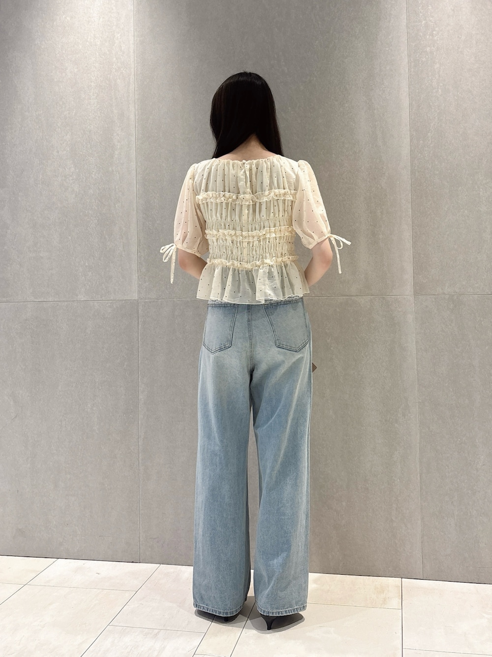 ホワイト系のシャツ/ブラウス、ホワイト系のショルダーバッグ、ブルー系のデニムパンツを着用したレディースの秋コーディネートの5枚目の写真