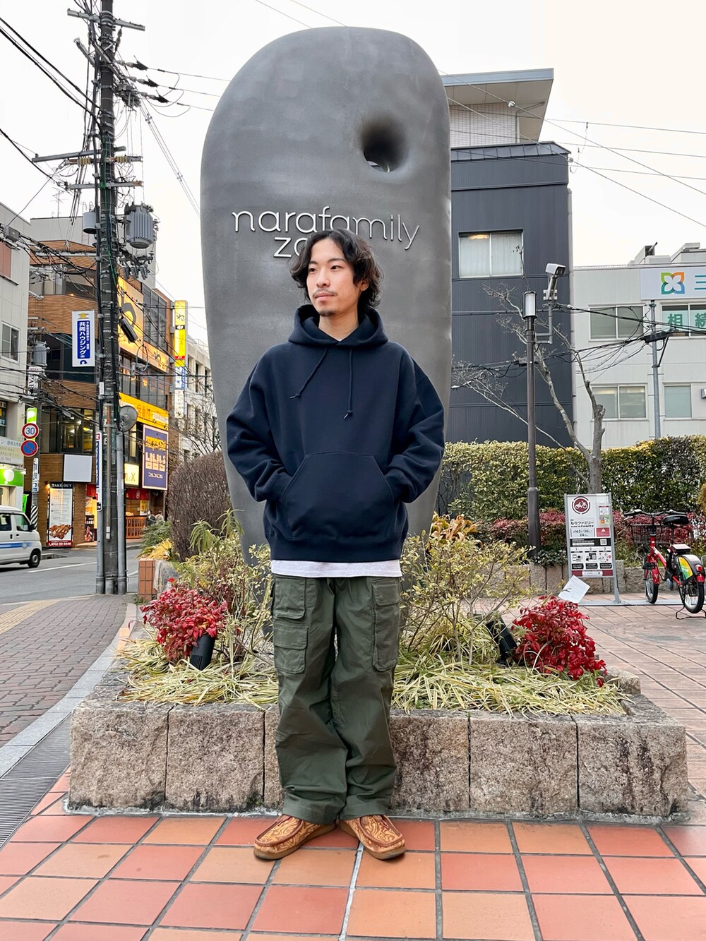 グリーン系のカーゴパンツ、ブルー系のパーカー、ブルー系のブルゾンを着用したメンズの春コーディネートの2枚目の写真