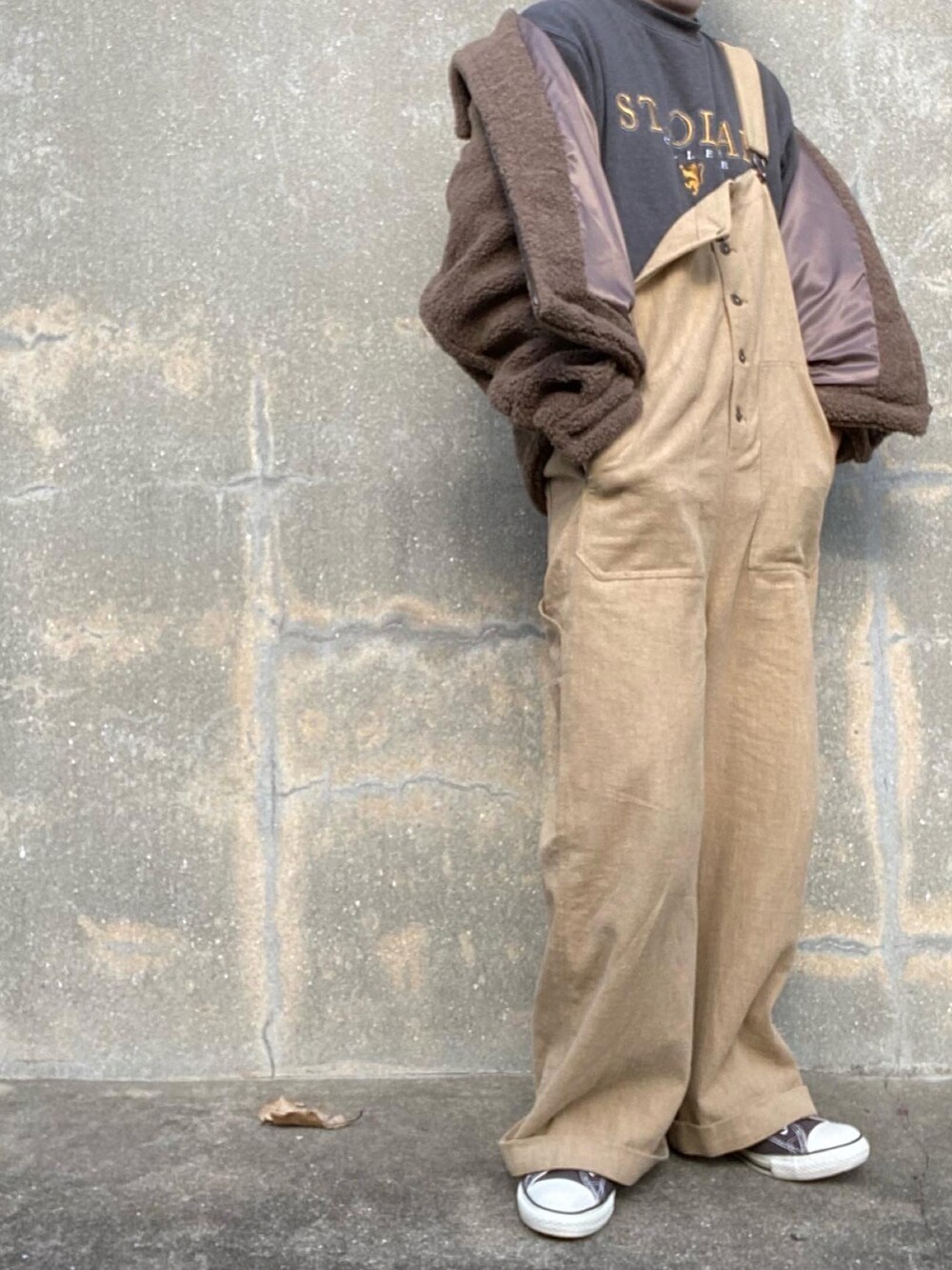 ベージュ系のサロペット/オーバーオール、ブラウン系のブルゾン、ブラック系のスウェットを着用したメンズの冬コーディネートの3枚目の写真