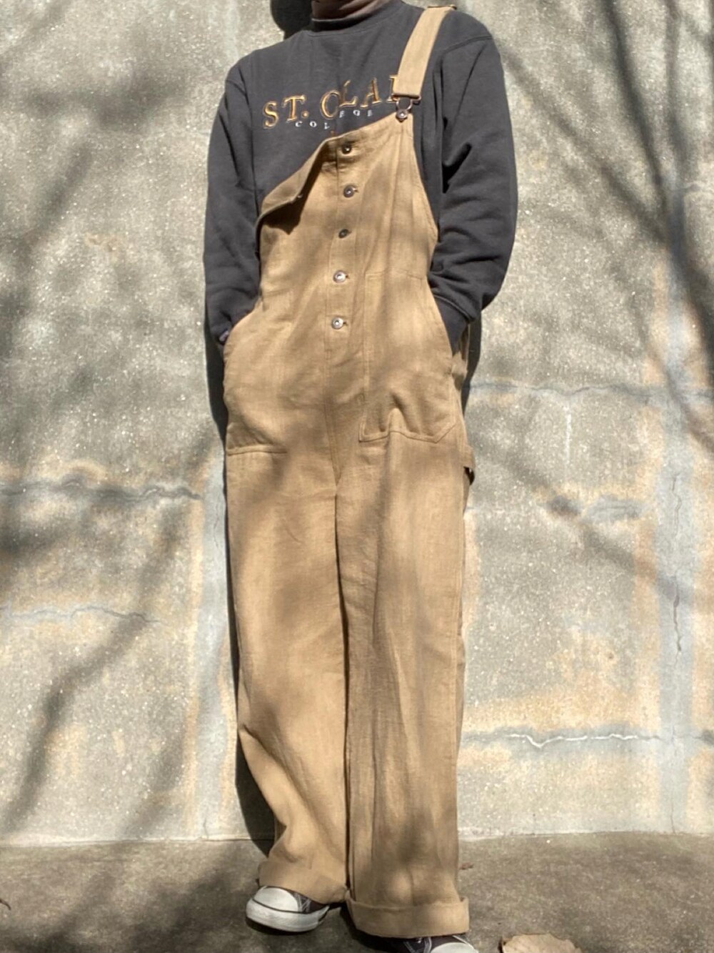 ベージュ系のサロペット/オーバーオール、ブラウン系のブルゾン、ブラック系のスウェットを着用したメンズの冬コーディネートの2枚目の写真