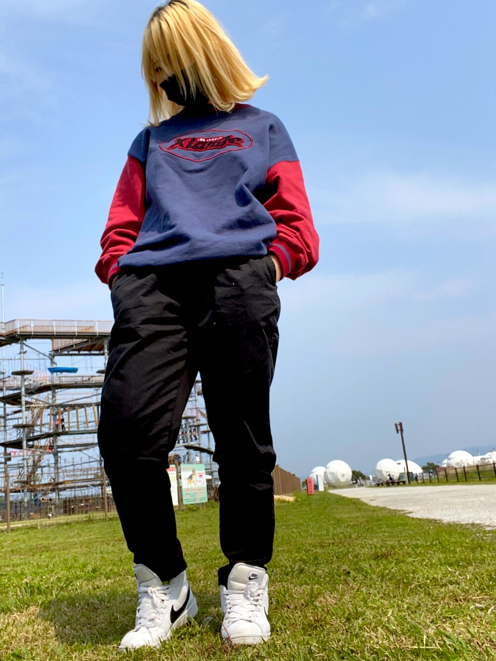 ブルー系のトップス、ブラック系のパンツ、ホワイト系のスニーカーを着用したレディースの夏コーディネートの2枚目の写真