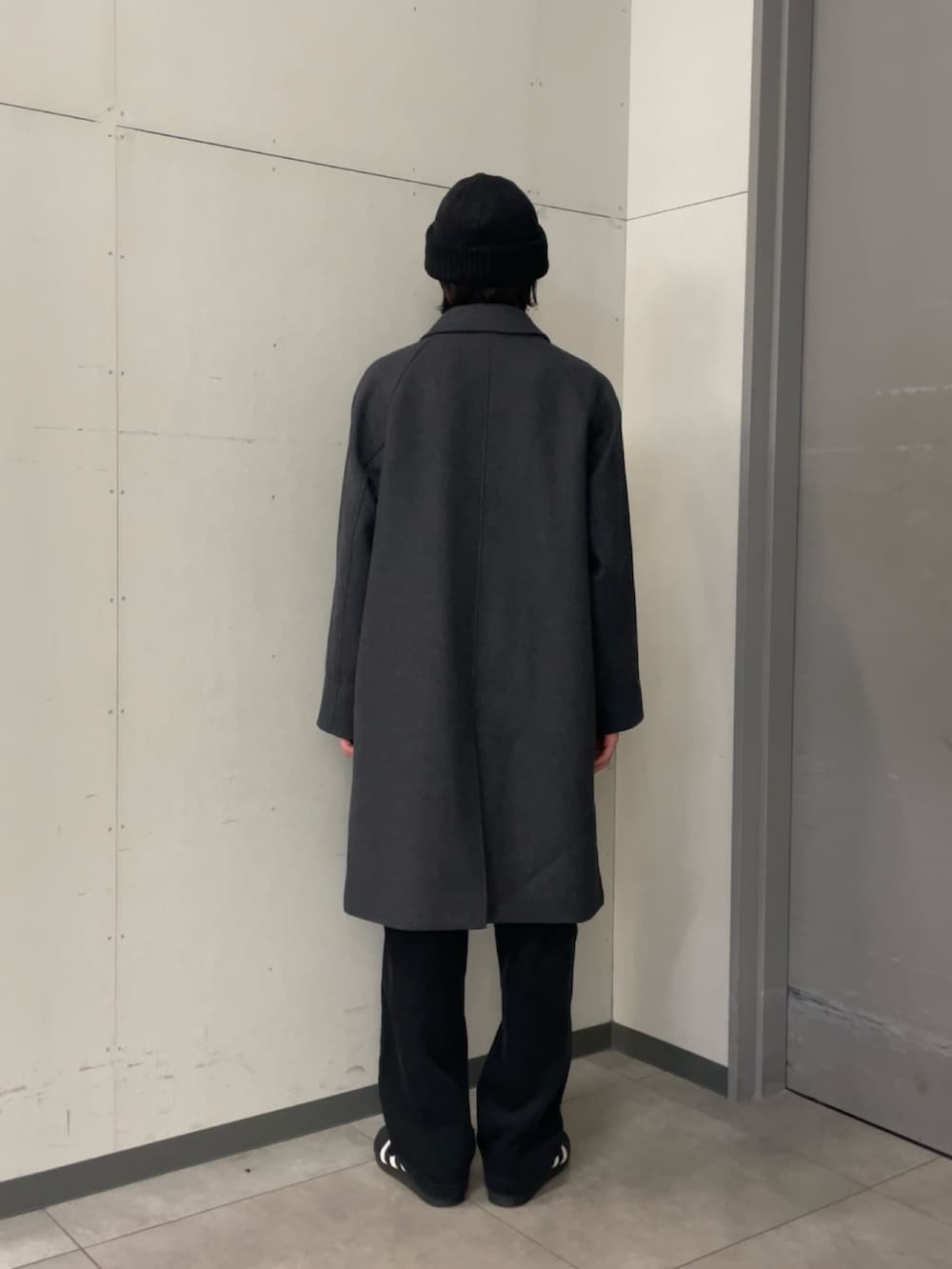 グレー系のステンカラーコート、ブラック系のニット/セーター、グレー系のその他パンツを着用したメンズの秋コーディネートの3枚目の写真