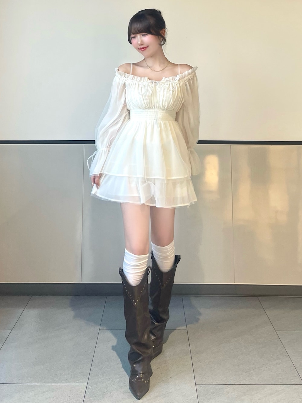 ホワイト系のワンピース、ブラウン系のボストンバッグを着用したレディースの春コーディネートの3枚目の写真