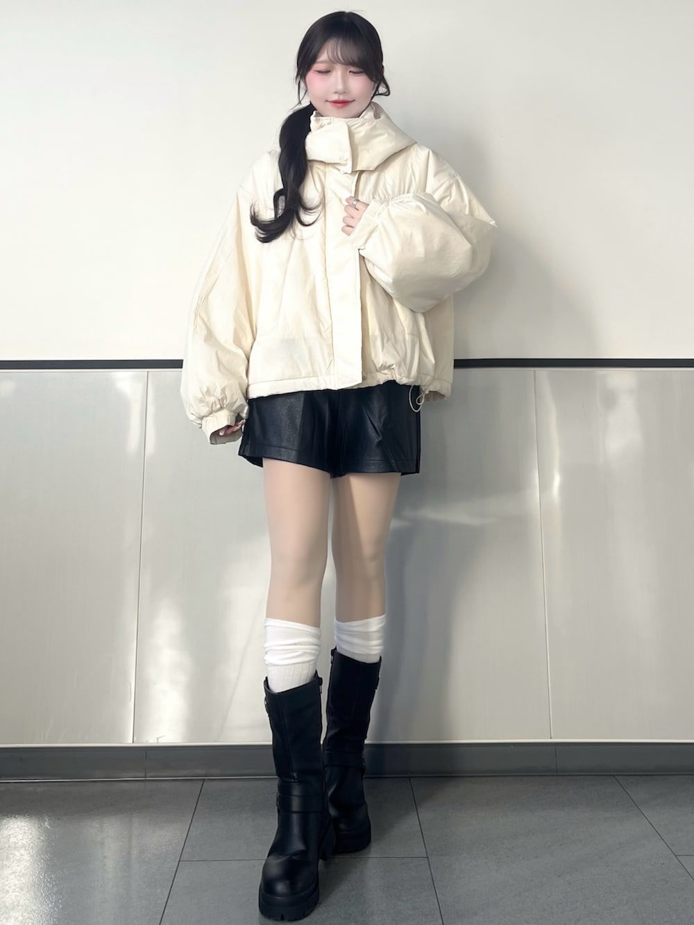 ホワイト系のブルゾン、ブラック系のその他パンツ、ブラック系のブーツを着用したレディースの秋コーディネートの2枚目の写真