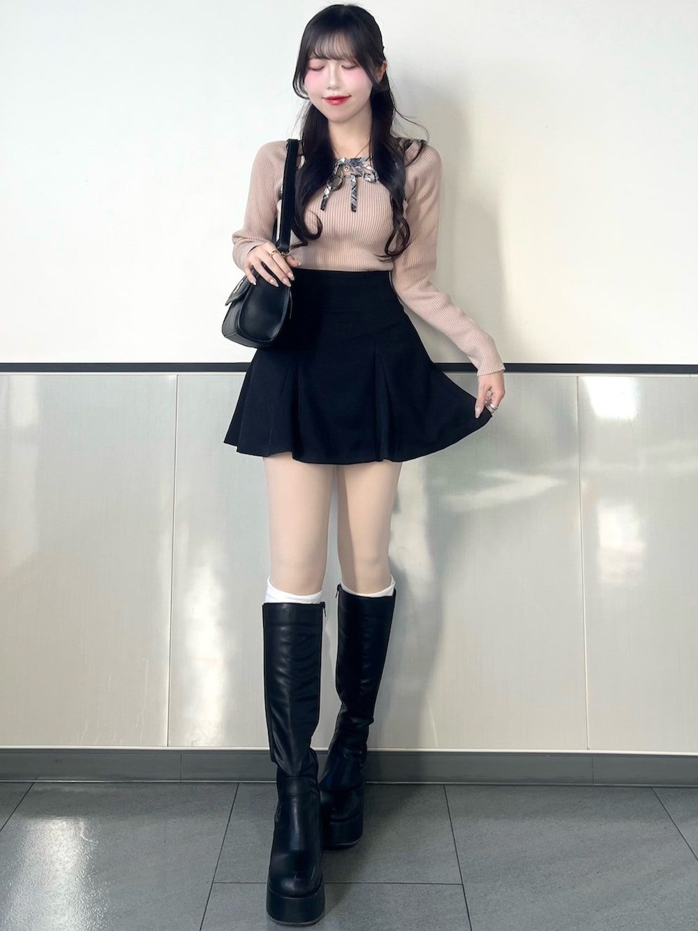 ベージュ系のニット/セーター、ブラック系のスカートを着用したレディースの冬コーディネートの2枚目の写真