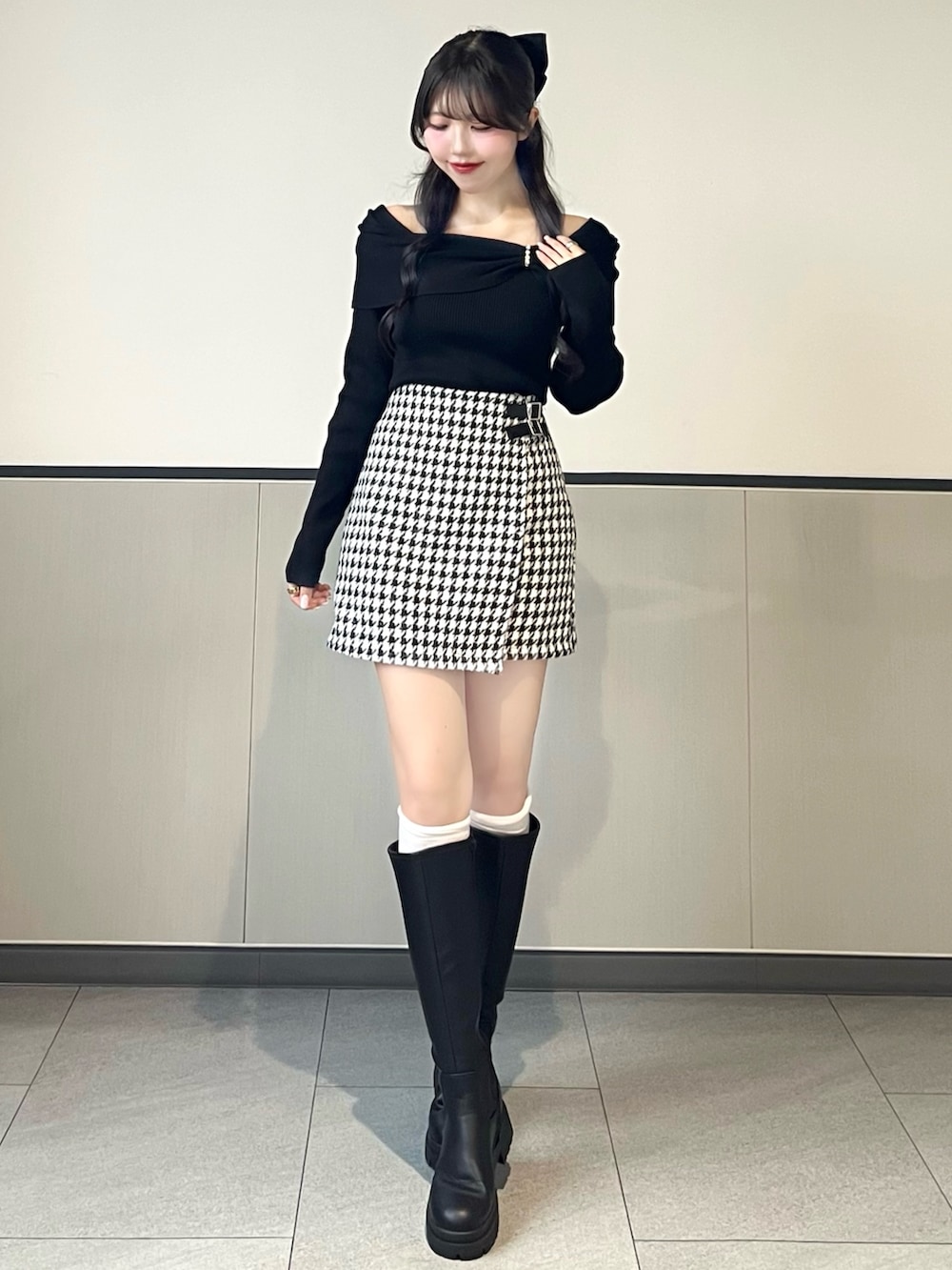 ブラック系のニット/セーター、その他のスカート、ブラック系のブーツを着用したレディースの秋コーディネートの2枚目の写真