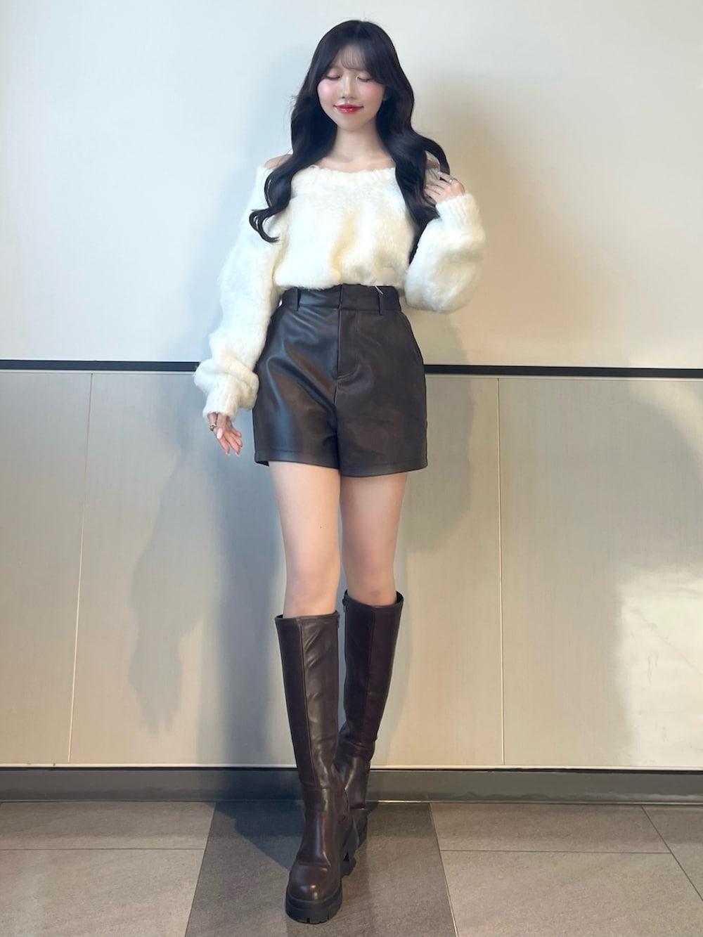 ホワイト系のニット/セーター、ブラウン系のその他パンツ、ブラウン系のブーツを着用したレディースの秋コーディネートの3枚目の写真