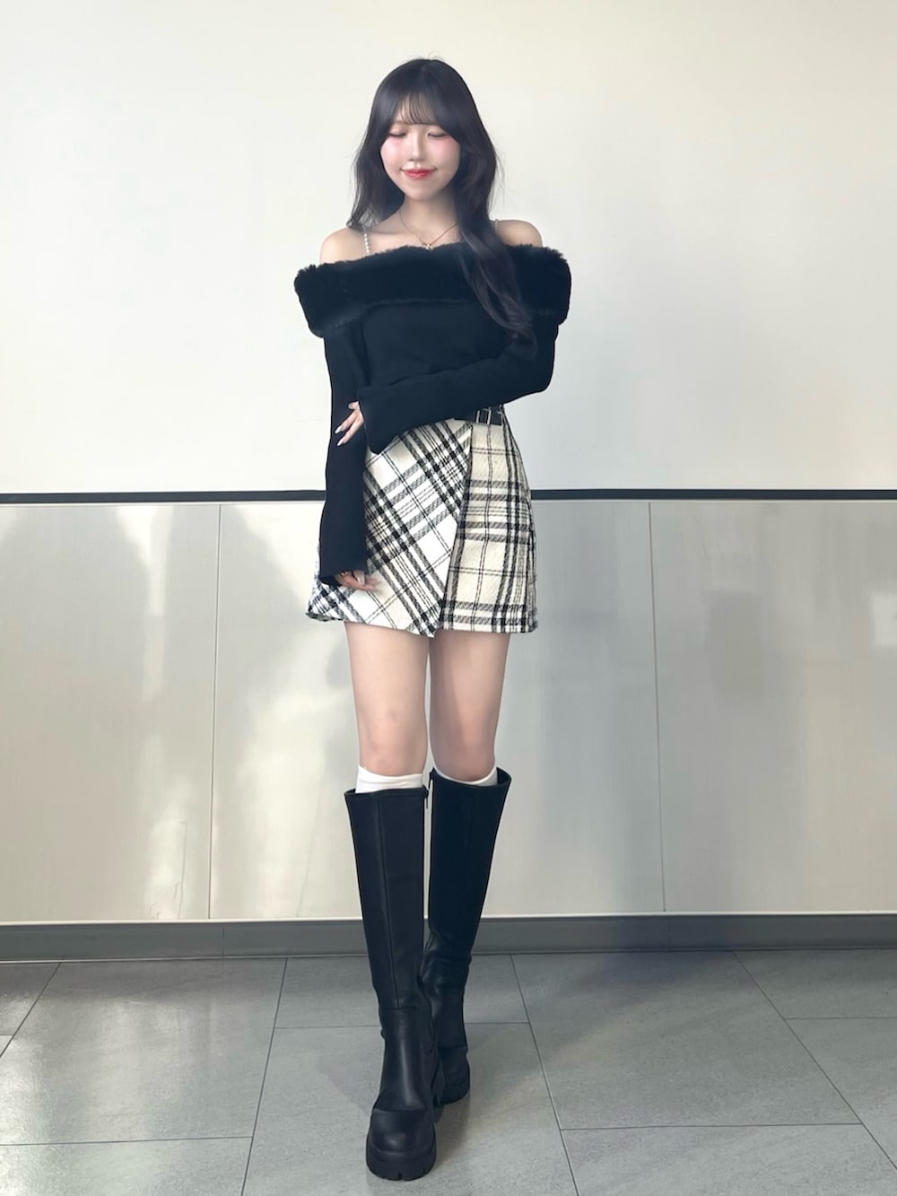 ブラック系のニット/セーター、ホワイト系のスカート、ブラック系のハンドバッグを着用したレディースの秋コーディネートの2枚目の写真